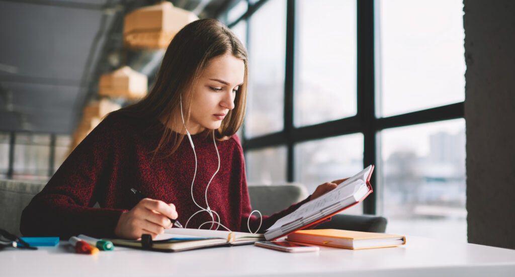 woman-headphones-reading-books-table