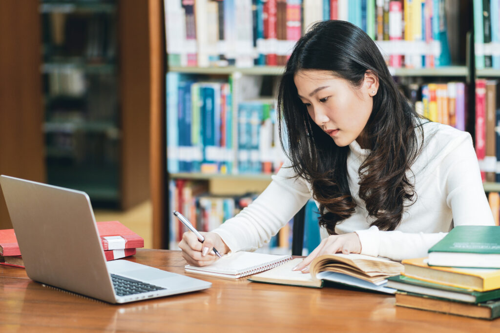 woman-writing-computer-table-library