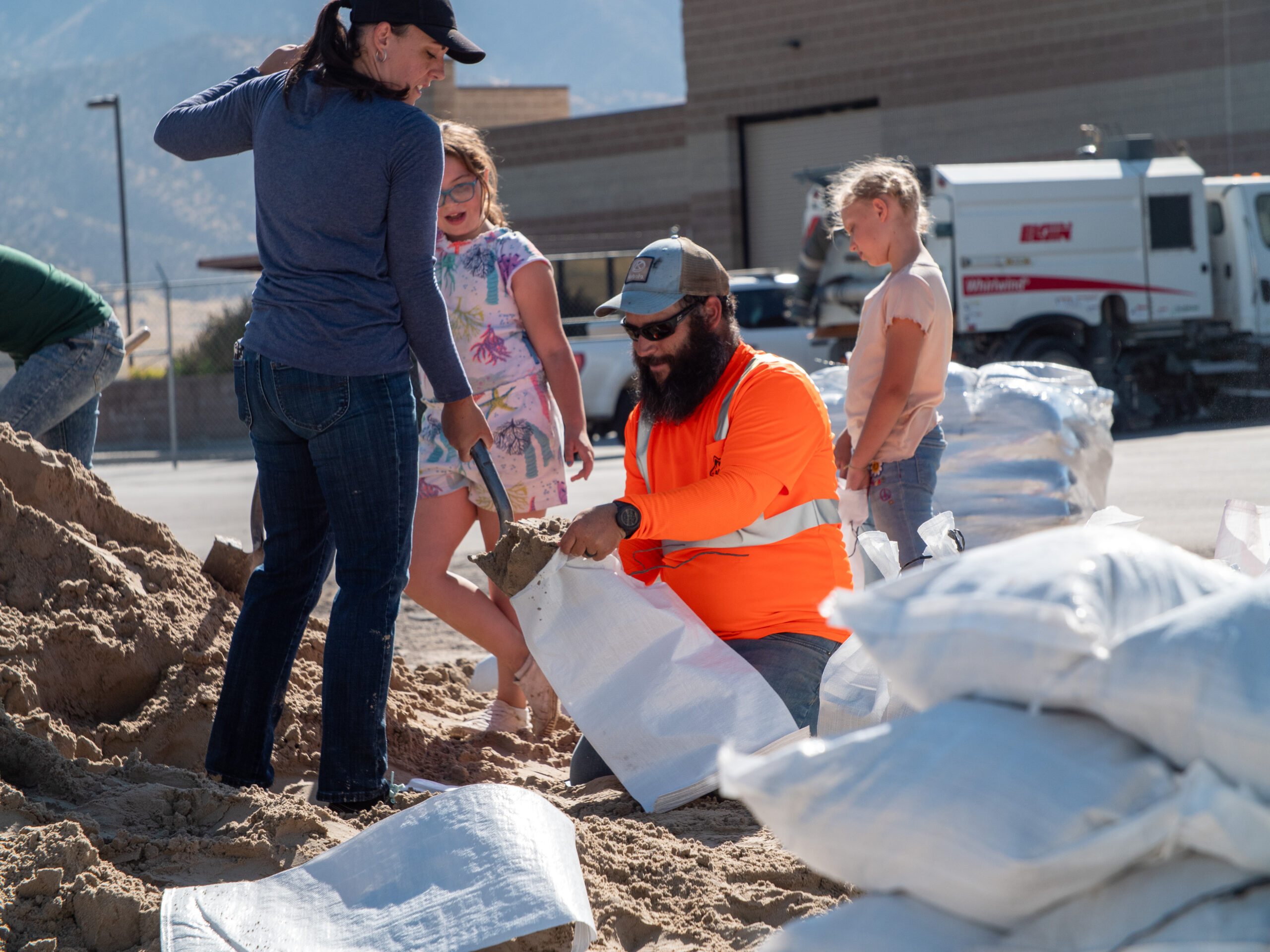 man-helping-woman-fill-sandbag