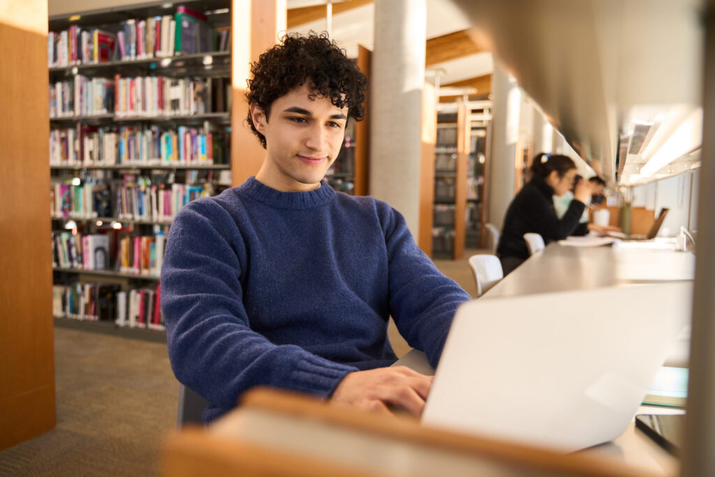 male-looking-at-computer-library