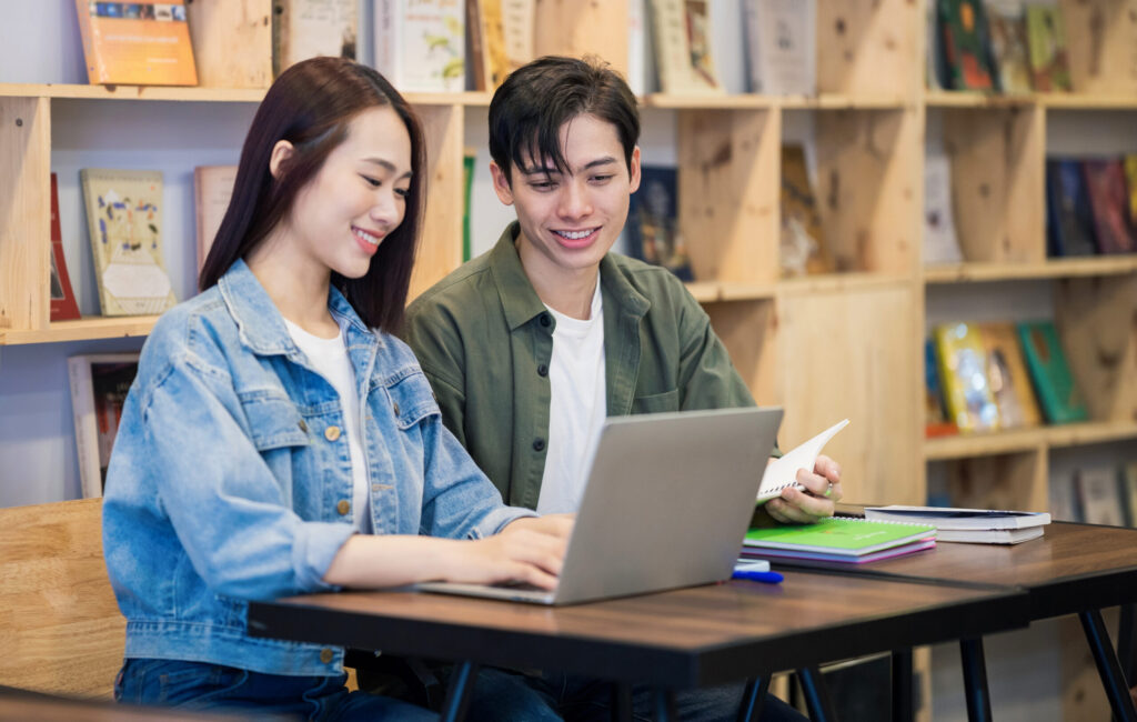 male-female-looking-at-computer-library